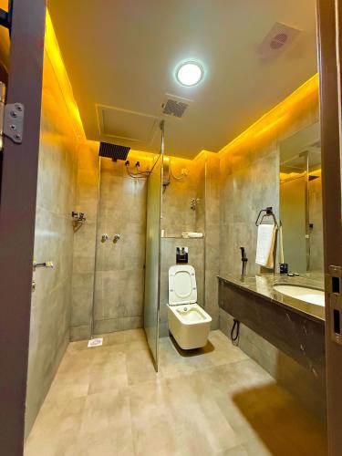 a bathroom with a toilet and a sink and a shower at Safari Resort & Convention Centre in Boorama