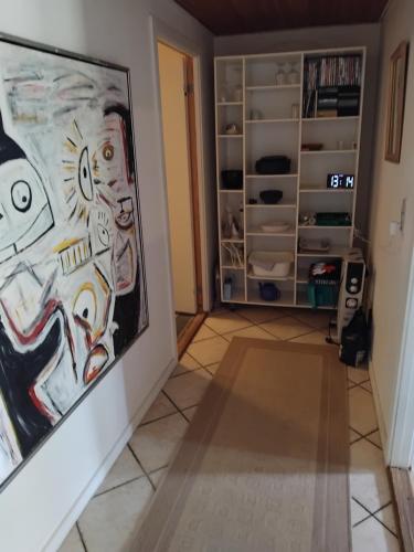 a room with a painting on the wall and a shelf at Dejligt og stort hus med spa og sauna in Roslev
