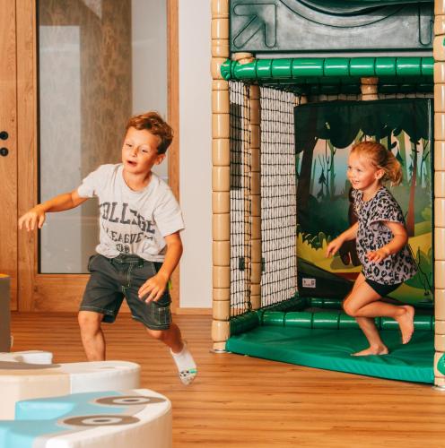 a boy and a girl playing in a play gym at Ferienhotel Sonnenhof in Zell am Ziller