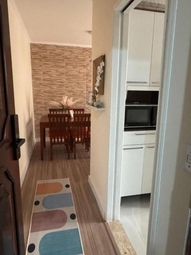 a kitchen and dining room with a table and white cabinets at Apto Mobiliado 15 m Aero Gru Garagem in Guarulhos