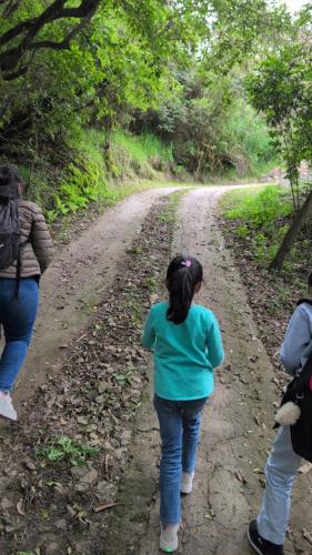 a group of people walking down a dirt road at The Black Sheep Inn in Chugchilán
