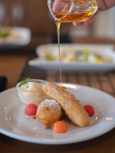 a person drizzling sauce on a plate with food at 360 Viewpoint by Queens Mount in Kandy