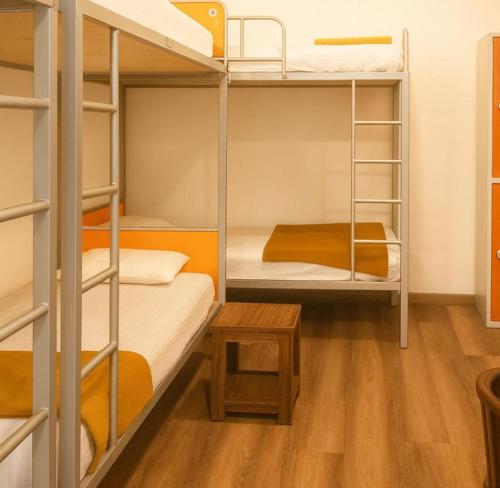 a room with three bunk beds and a table at CityRest Fort in Colombo