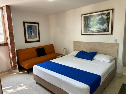 a bedroom with a bed and a couch at Amoblados Medellín Laureles in Medellín