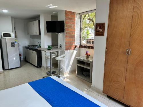 a room with a kitchen with a refrigerator and a table at Amoblados Medellín Laureles in Medellín