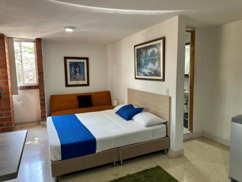 a bedroom with a bed with blue and white sheets at Amoblados Medellín Laureles in Medellín