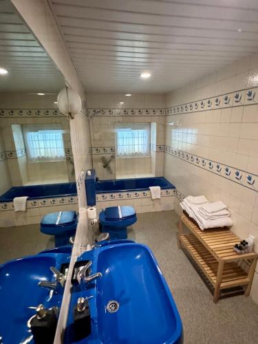 a bathroom with three blue toilets and a tub at Casa da Quinta De S. Martinho in Vila Real