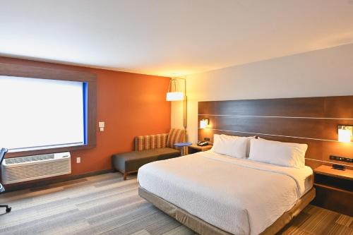 a hotel room with a bed and a flat screen tv at Holiday Inn Express Houghton-Keweenaw by IHG in Houghton
