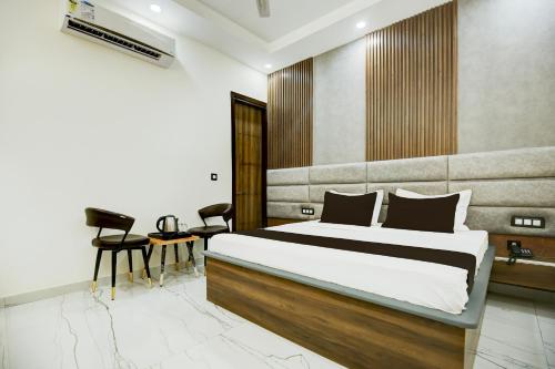 a bedroom with a bed and a table and chairs at Hotel O Platinum in Zirakpur