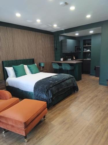 a bedroom with a large bed and a kitchen at The Green Room in Tideswell