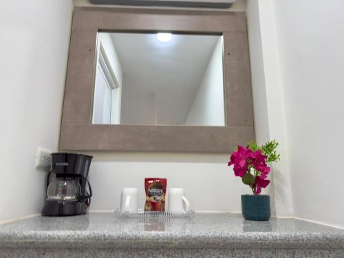 a bathroom counter with a mirror and a sink at Forest 15 min from Manta Beach in Pacoche