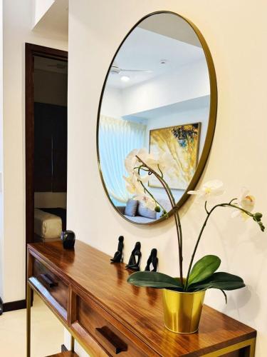 a mirror on a wall above a dressing table with a plant at YAKA Trizen Luxury Apartments - 53rd and 51st Floor with Stunning Views in Colombo