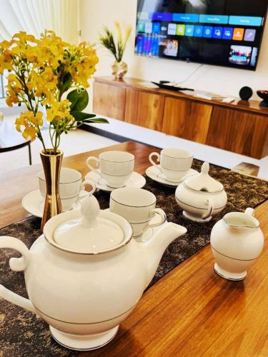 a table with a tea pot and cups and flowers at YAKA Trizen Luxury Apartments - 53rd and 51st Floor with Stunning Views in Colombo