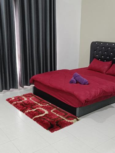 a bedroom with a red bed and a red rug at Ateh's Homestay KLIA in Sepang