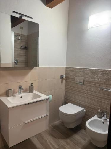 Un baño con lavabo, inodoro y espejo. en Il nido dei Medici, en Montelupo Fiorentino