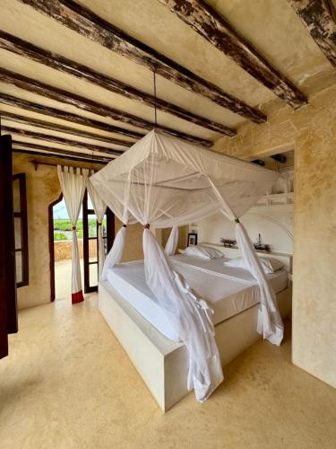 a bedroom with a bed with a mosquito net at Nyumba ya mwezi in Lamu