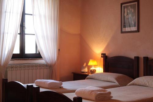 a bedroom with two beds and a window at Casanova - Wellness Center La Grotta Etrusca in San Quirico dʼOrcia