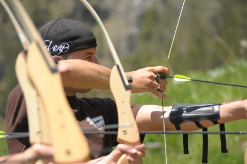 a man is holding a bow and arrow at Hotel Gut Brandlhof in Saalfelden am Steinernen Meer