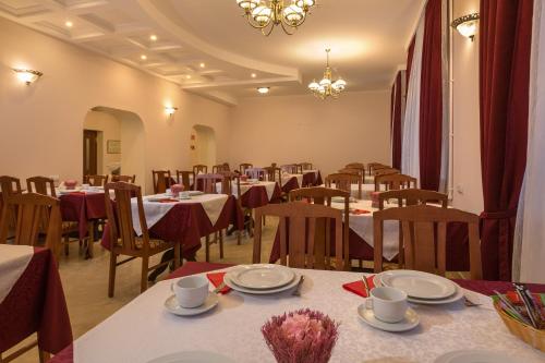 uma sala de jantar com mesas e cadeiras e um lustre em Avetpark Hotel em São Petersburgo