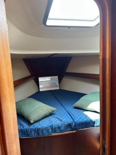 a small bed in the middle of a room at Baby Two Sailing Boat in Limanu