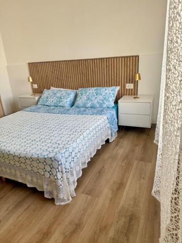 a bedroom with a bed and a wooden floor at Casa Rosmarino in Carbonia
