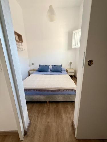 a bedroom with a bed with blue pillows on it at Casa Rosmarino in Carbonia
