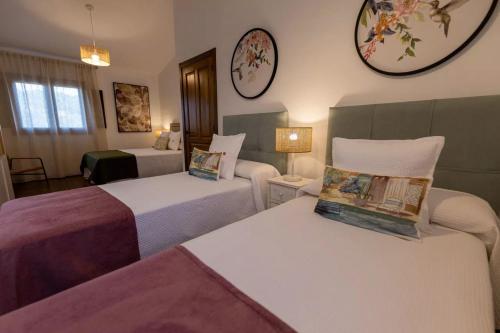 a hotel room with two beds and clocks on the wall at Apartamentos Rurales la Campiña in Casiñas Bajas