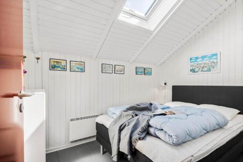 Un dormitorio con una cama con una manta azul encima. en 0293-Romo-Vestergade-3-Ap-56, en Havneby