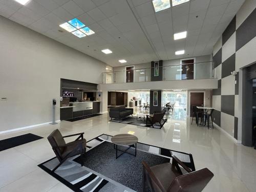 a large living room with chairs and a table at HOM Hotel Gainesville, SureStay Collection by Best Western in Gainesville