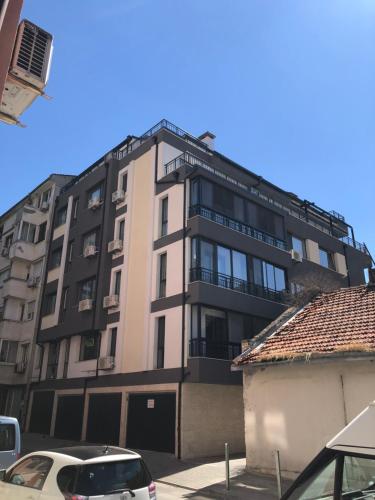 a tall building with cars parked in front of it at Гнездото l The Nest in Burgas City