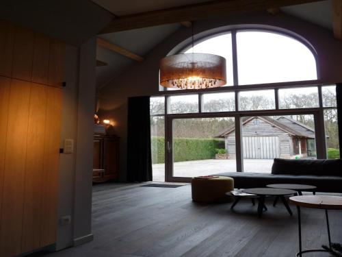 a living room with a couch and a large window at Cozy Holiday Home in Aalter near Lake in Maria Aalter