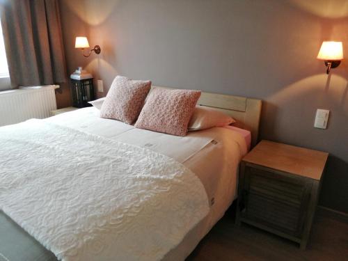 a bedroom with a white bed with two pillows at Cozy Holiday Home in Aalter near Lake in Maria Aalter