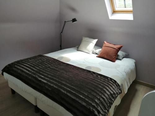 a bed with pillows on it in a room at Cozy Holiday Home in Aalter near Lake in Maria Aalter
