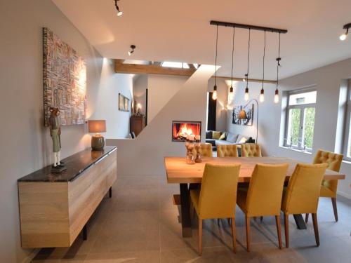 a dining room with a table and chairs and a fireplace at Cozy Holiday Home in Aalter near Lake in Maria Aalter