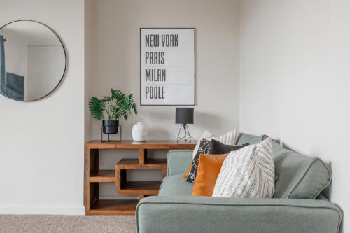 a living room with a green couch and a mirror at Parkstone Central by Grandeur Property in Parkstone