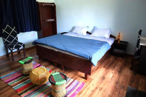 a bedroom with a bed with a blue comforter and some baskets at The Chimes House in Kausani