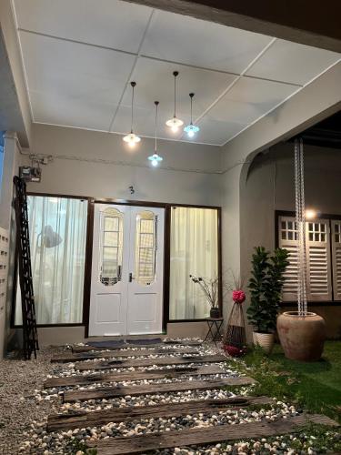 a hallway with a white door and some plants at KY Homestay in Gua Sai