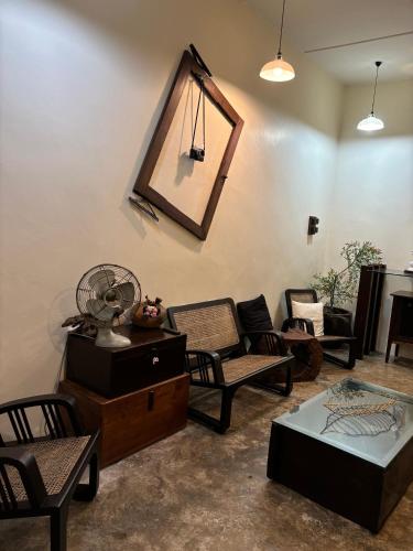 a living room with chairs and a mirror on the wall at KY Homestay in Gua Sai