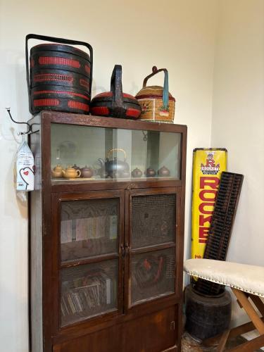 a wooden cabinet with glass doors and baskets on top at KY Homestay in Gua Sai