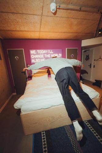a person laying on a bed in a room at Villa Viva - ein Haus das Brunnen baut in Hamburg