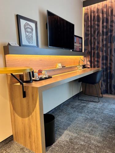 a desk with a television on top of it at Holiday Inn - Hamburg - HafenCity by IHG in Hamburg