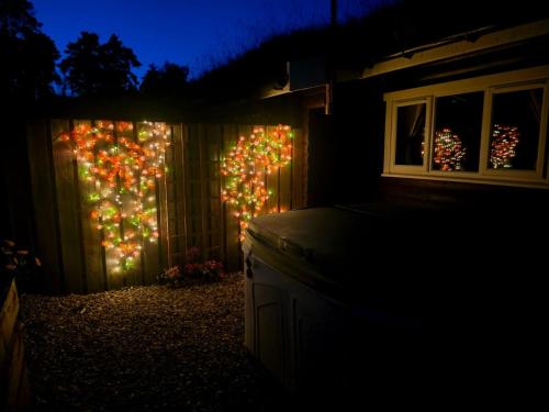 a fence with christmas lights on it at night at Kaoglen-Blossom-Hot tub-Cairngorms-Pet Friendly in Balnald