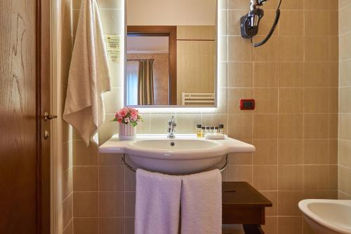 a bathroom with a sink and a mirror at Casanova - Wellness Center La Grotta Etrusca in San Quirico dʼOrcia