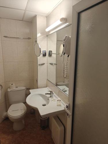 a bathroom with a toilet and a sink and a mirror at Noviz Hotel in Plovdiv