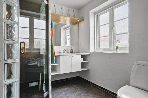 a bathroom with a sink and a toilet and windows at 0371-Romo-Sonder-Frankel-4 in Havneby