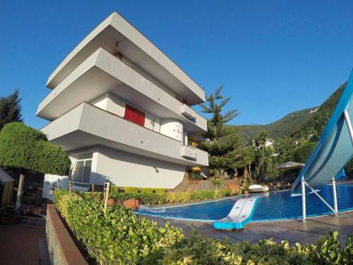 a building with a swimming pool next to a resort at Villa Eden in Corbara