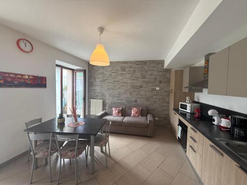 a kitchen and living room with a table and a couch at Casa La Pief 1 Giallo by Gardadomusmea in Tremosine Sul Garda