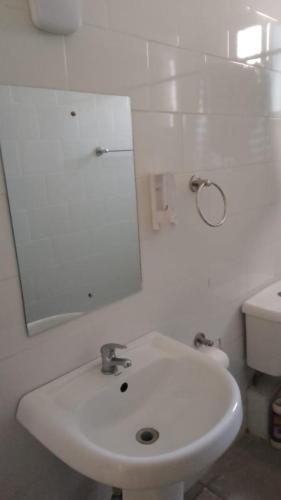a white bathroom with a sink and a mirror at Kijani unique home Malindi in Malindi