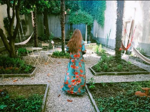 a girl in a dress standing in a garden at Ostello Bello Lake Como in Como