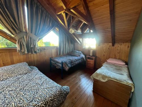 a room with two beds and a window in a cabin at Casona Frente al mar Caicaen in Caicaén